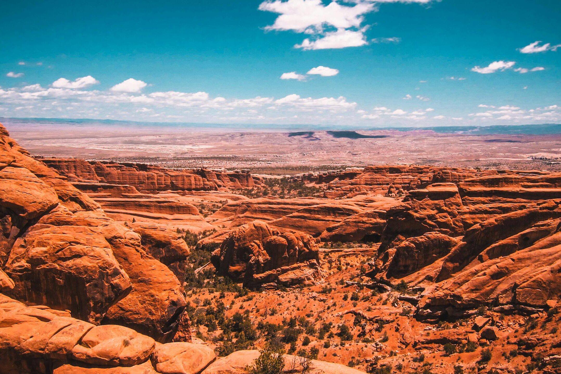 Beautiful view of a red rock desert canyon under a clear blue sky, showcasing natural geological formations.